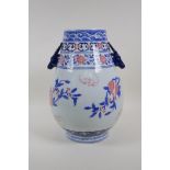 A blue and white porcelain vase with two stag mask handles, decorated with red bats and