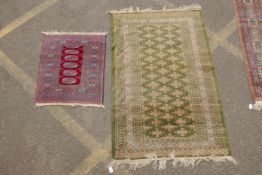 A terracotta ground wool bokhara prayer rug, and a Persian green ground wool rug with a blue and