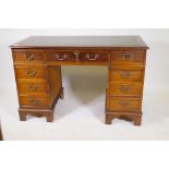 A yew wood eight drawer pedestal desk, 47" x 24" x 30", with gilt tooled leather inset top