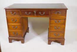 A yew wood eight drawer pedestal desk, 47" x 24" x 30", with gilt tooled leather inset top