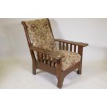 An oak Arts & Crafts arm chair with patent pull out foot stool, bears label, Rd at the Patent