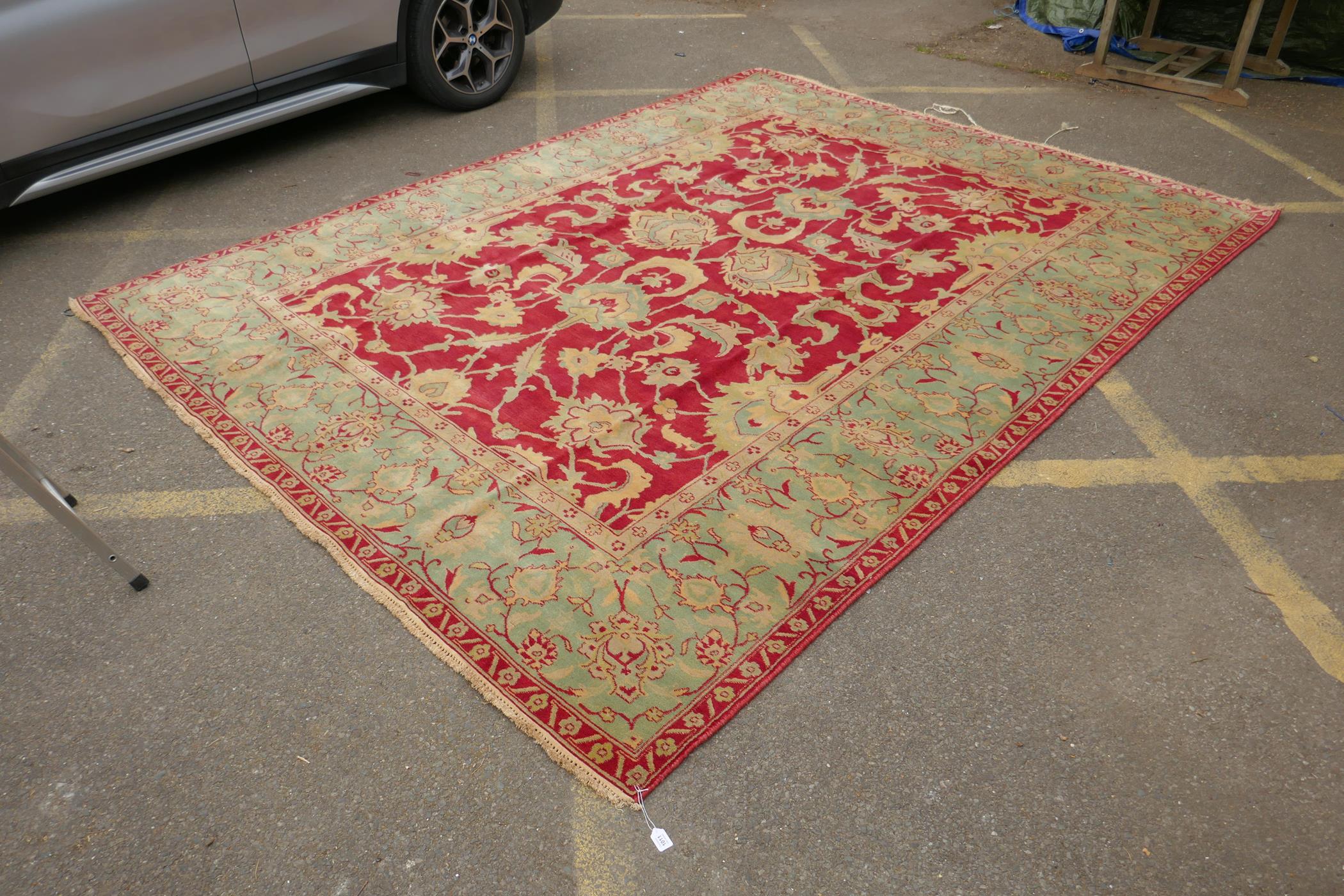 An antique red ground Agra carpet with floral design and olive green borders, AF wear, 108" x 140" - Image 3 of 8