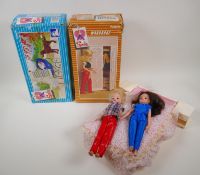 Two 1970s Sindy Dolls with jointed knees, a double bed, wardrobe, dressing table and pram, the
