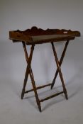 A walnut butler's tray with shaped three quarter gallery and folding stand, 26" x 17"