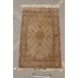 An Iranian cream ground silk rug decorated with a multi colour geometric medallion design, signed,