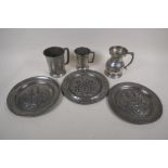 Three C19th pewter plaques embossed with coats of arms, 9" diameter, and three pewter tankards