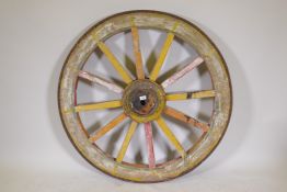 An Indian painted wood and iron bound cartwheel, 47" diameter