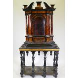 A continental baroque tortoiseshell and ebony tabernacle cabinet, with swan neck pediment over an