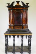 A continental baroque tortoiseshell and ebony tabernacle cabinet, with swan neck pediment over an