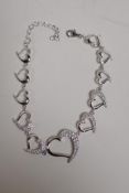 A sterling silver and cubic zirconia set bracelet with graduated heart shaped links, 9" long