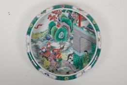 A famille vert porcelain dish with a rolled rim, decorated with warriors on horseback, Chinese