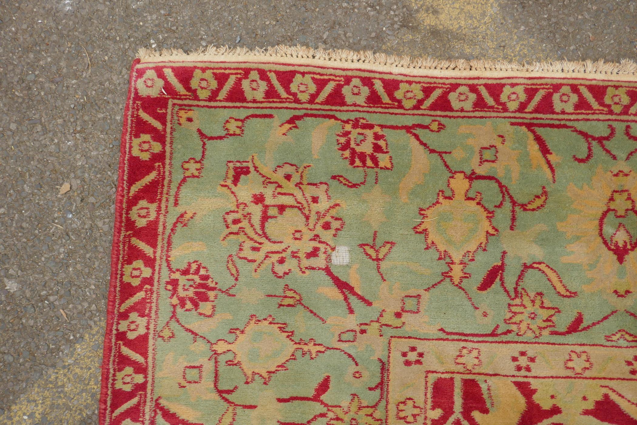 An antique red ground Agra carpet with floral design and olive green borders, AF wear, 108" x 140" - Image 5 of 8