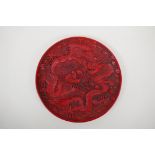 A Chinese cinnabar lacquer style dish decorated with two dragons chasing the flaming pearl,