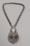 A silver bracelet with heart shaped links and a padlock style clasp in the form of an owl, set