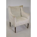 A C19th easy chair with shaped wing sides, raised on fluted tapering supports
