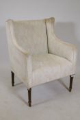 A C19th easy chair with shaped wing sides, raised on fluted tapering supports