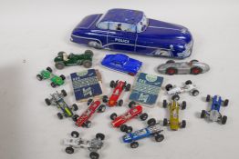 A British made tin plate toy police car, a quantity of 'penny' racing cars, and two Castrol 'Speed