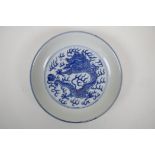 A blue and white porcelain dish decorated with a dragon chasing the flaming pearl, Qianlong seal