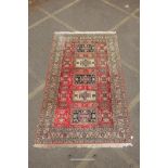 A pink ground wool and silk Persian Ardabil rug with medallion design, worn, 65" x 102"
