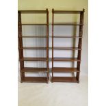 A pair of teak open shelves, with ring turned end supports, one lacking finial, 32" x 12" x 80"