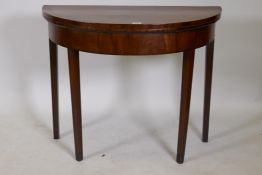 A Georgian mahogany fold over demi lune tea table with inlaid edges, raised on square tapering