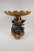 A bronze and ormolu centre piece decorated with putti, and a clam shell bowl, on a triform base, 13"