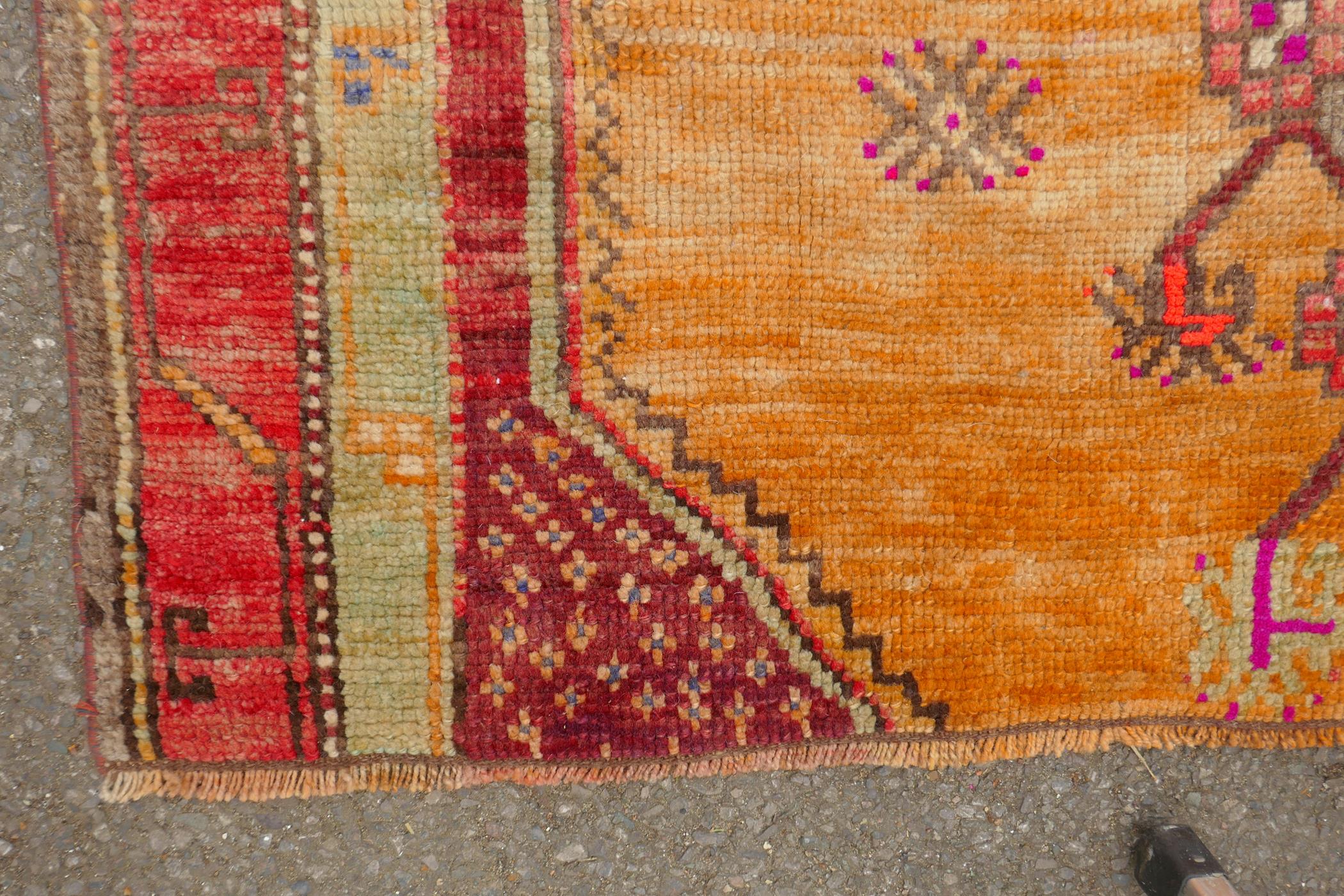 An Afghan rust ground full pile wool carpet with a tri-colour medallion design, 57" x 97" - Image 4 of 5