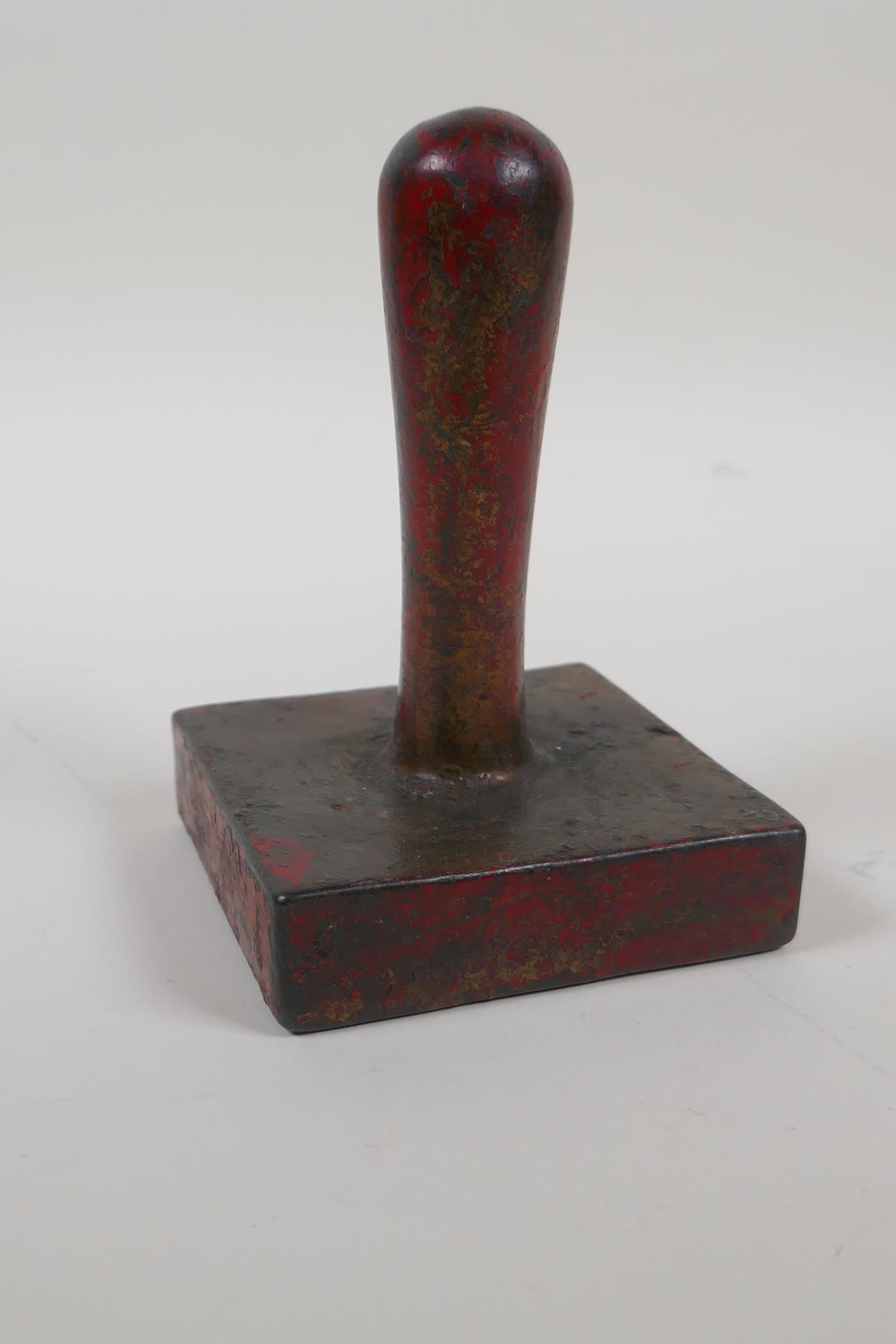 A Chinese filled bronze seal/stamp with the remnants of gilt and copper patina, 5" high