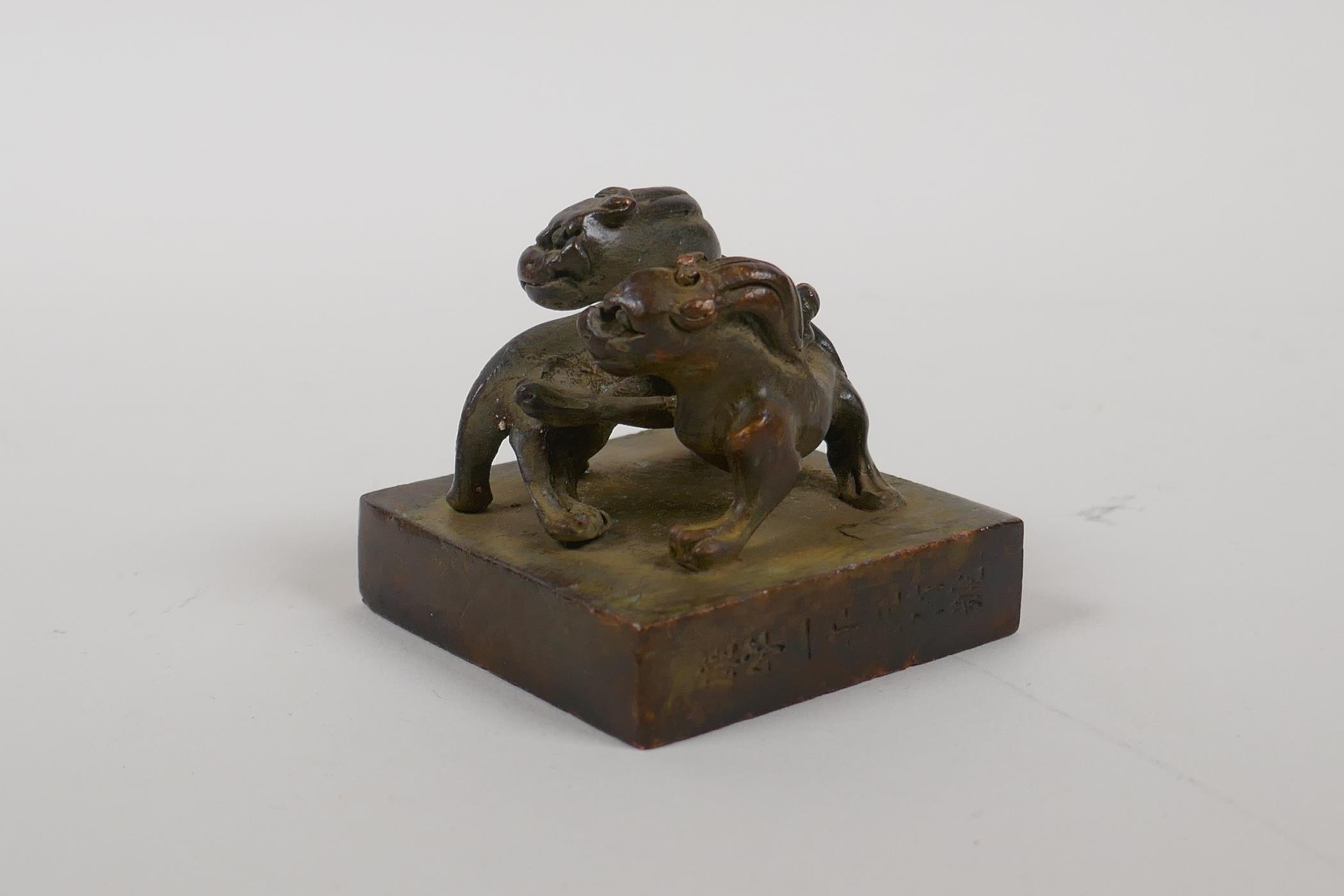 A Chinese archaic style bronze seal with two entwined kylin as a knop, 2" x 2" - Image 2 of 5