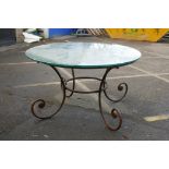 A wrought iron garden / conservatory table with plate glass top, 53" diameter, 30" high