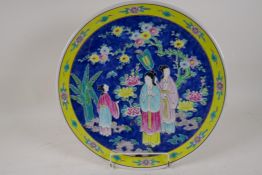 A Chinese porcelain charger painted in bright enamels with a lady and her servants, 16" diameter