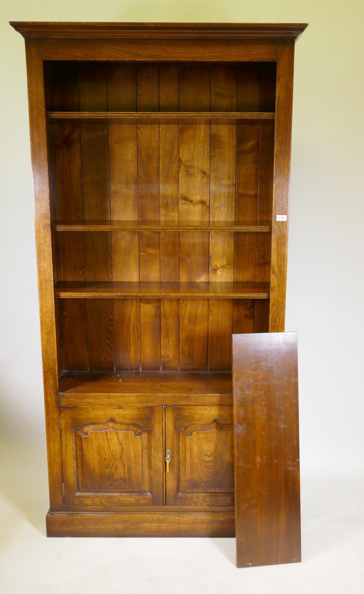 An oak open bookcase over two cupboard doors, 41½" x 13½", 80½" high