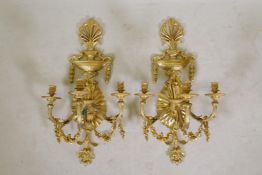 A pair of ormolu three branch wall sconces decorated with floral swags, acorns and arrow