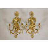 A pair of ormolu three branch wall sconces decorated with floral swags, acorns and arrow