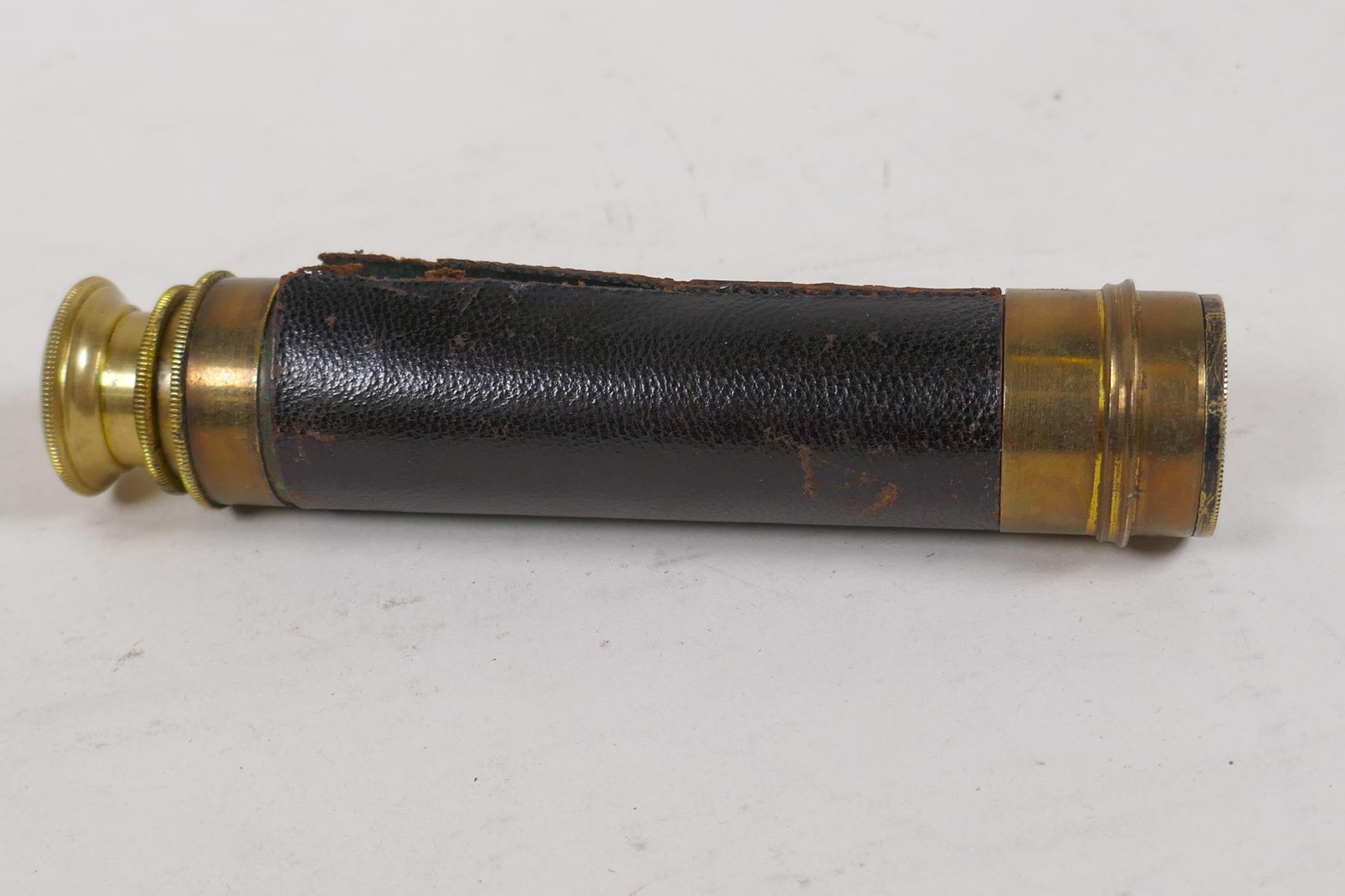 An antique brass three draw pocket telescope, 14" long open