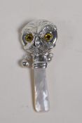 A sterling silver and mother of pearl baby's rattle in the form of an owl head, 3" long