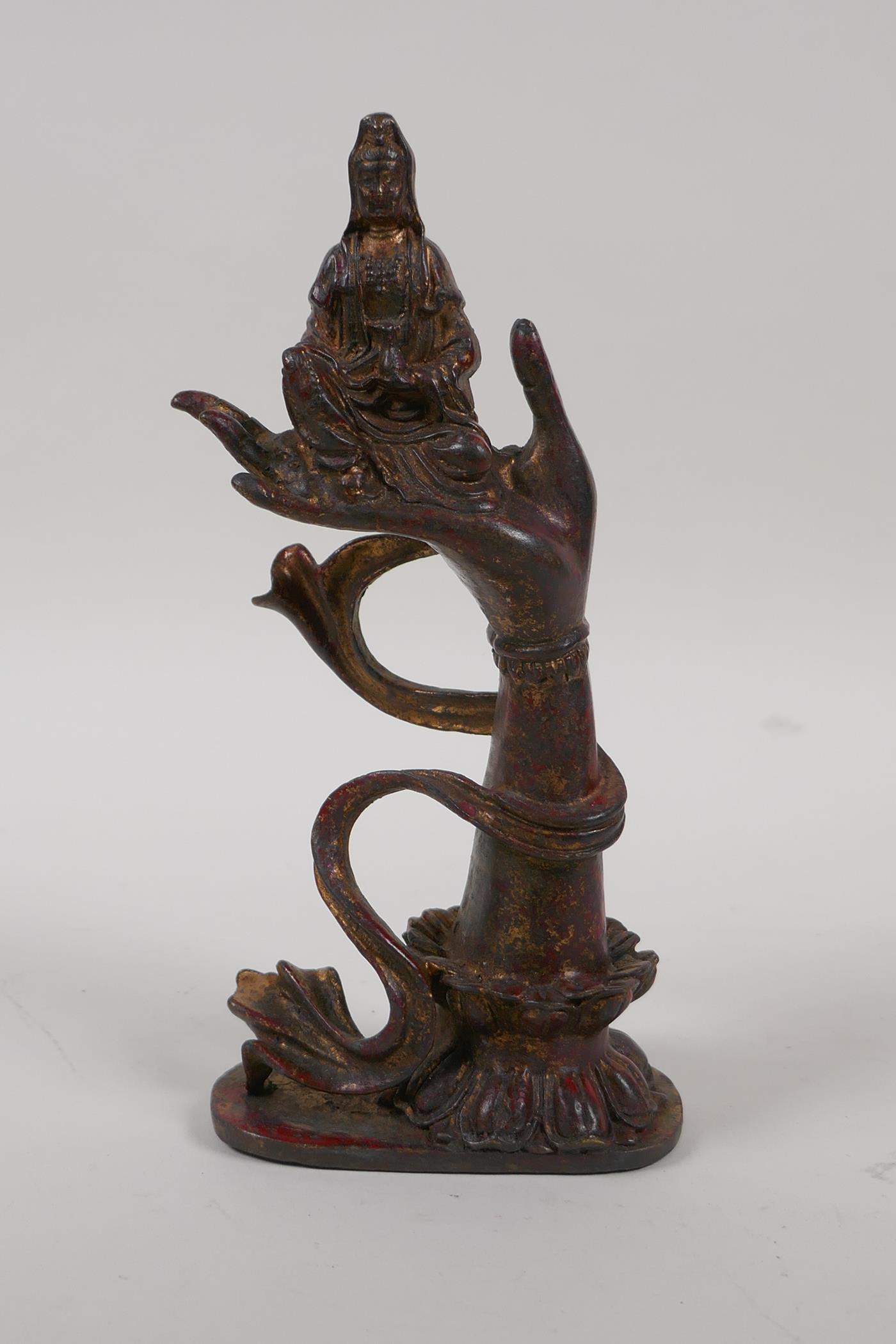 A Chinese gilt bronze figure of Quan Yin, seated on a hand, impressed 4 character mark to base,