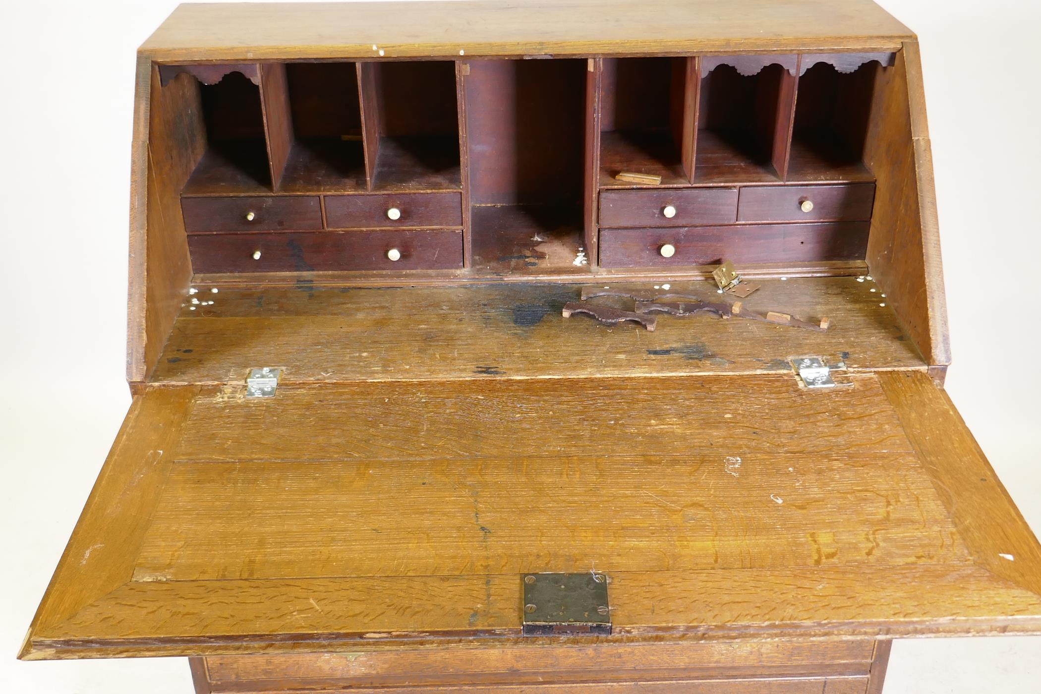 A Georgian oak fall front bureau, the interior fitted with drawers and pigeon holes over four long - Image 2 of 5