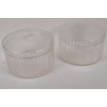 A pair of ribbed cut glass storage jars and covers, 8" diameter