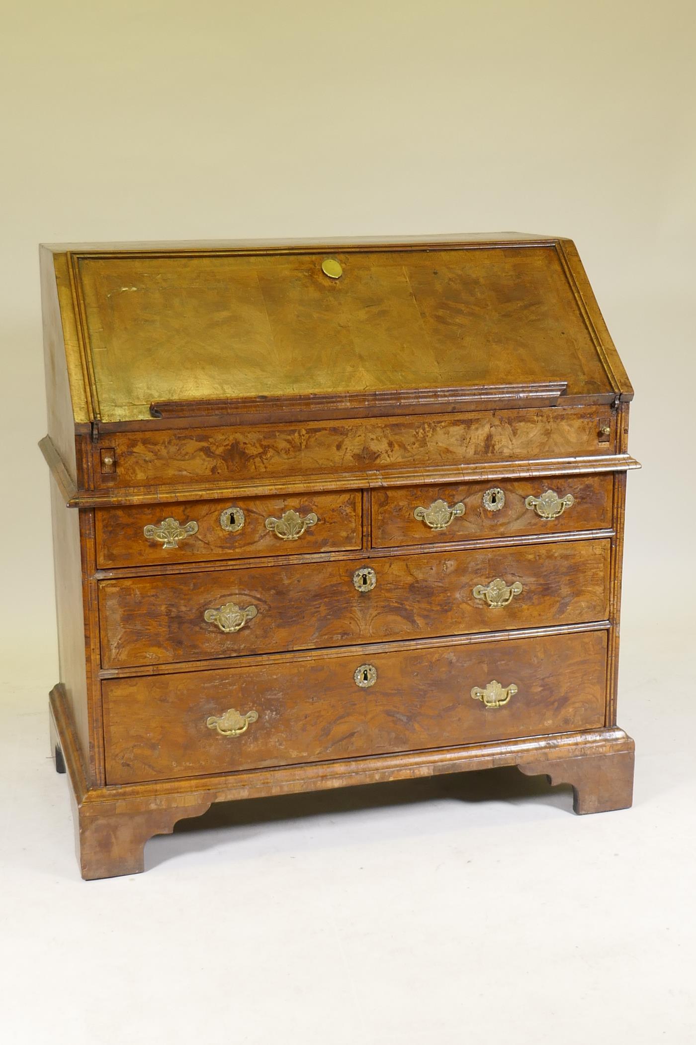 An C18th feather banded and figured walnut fall front bureau, the stepped interior with concave