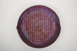 A Chinese shallow porcelain dish with a shaped rim, junware glaze and a chased character
