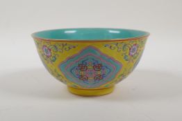 An enamelled porcelain rice bowl with famille rose decoration on a yellow ground and a turquoise
