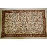 An old Turkish Hereke hand woven cream ground woven wool rug with an allover floral design, 55" x