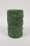 A Chinese green hardstone brush pot with carved decoration of figures in a landscape, 5" high