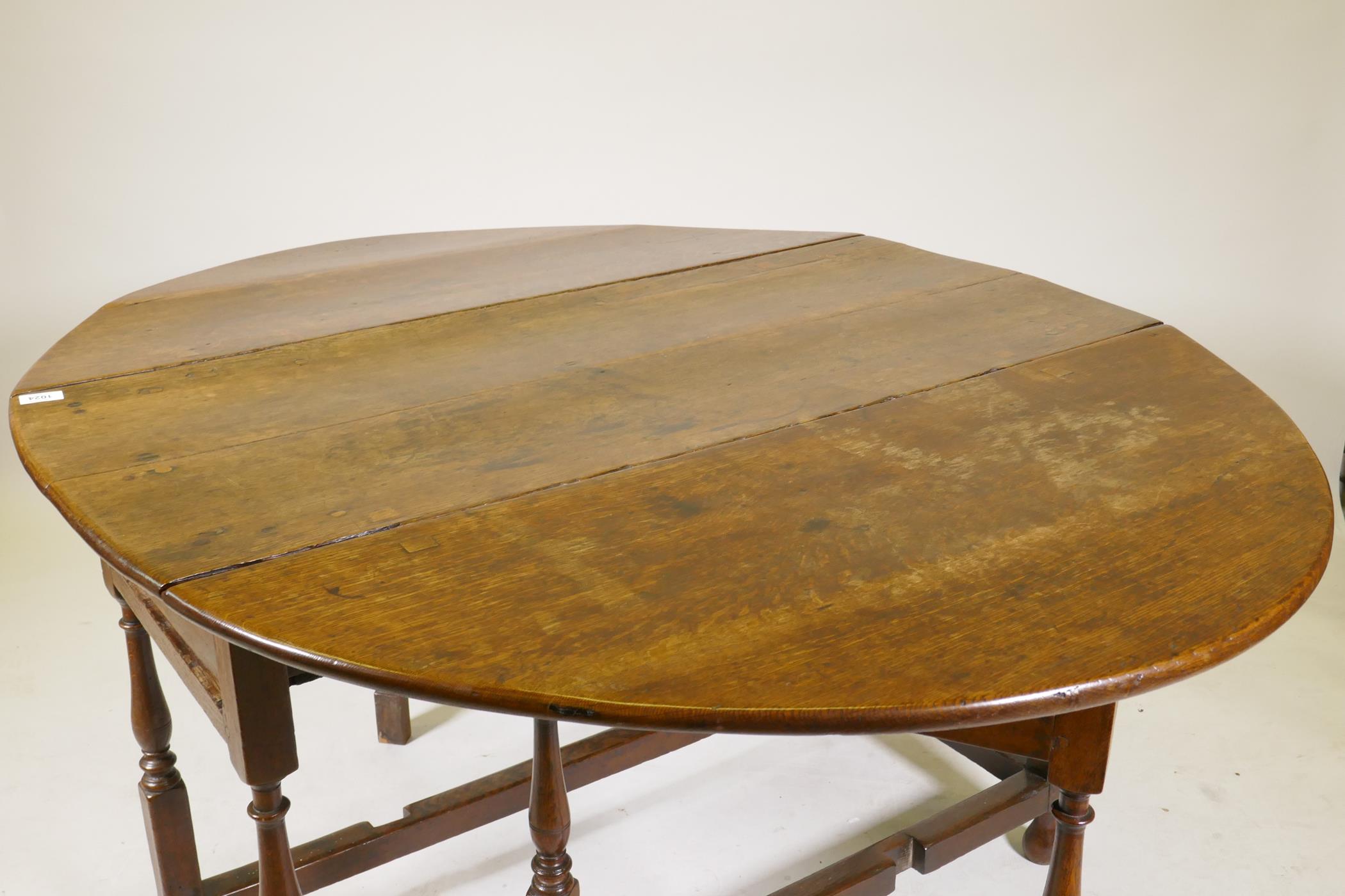 An C18th oak gateleg drop leaf table with single long drawer, raised on turned baluster shaped - Image 5 of 5