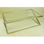 A contemporary glass topped coffee table on a chrome cross frame base, 55" x 31½" x 17½"