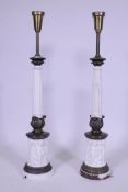 A pair of painted metal table lamps with brass mounts, fluted columns and raised putti decoration,