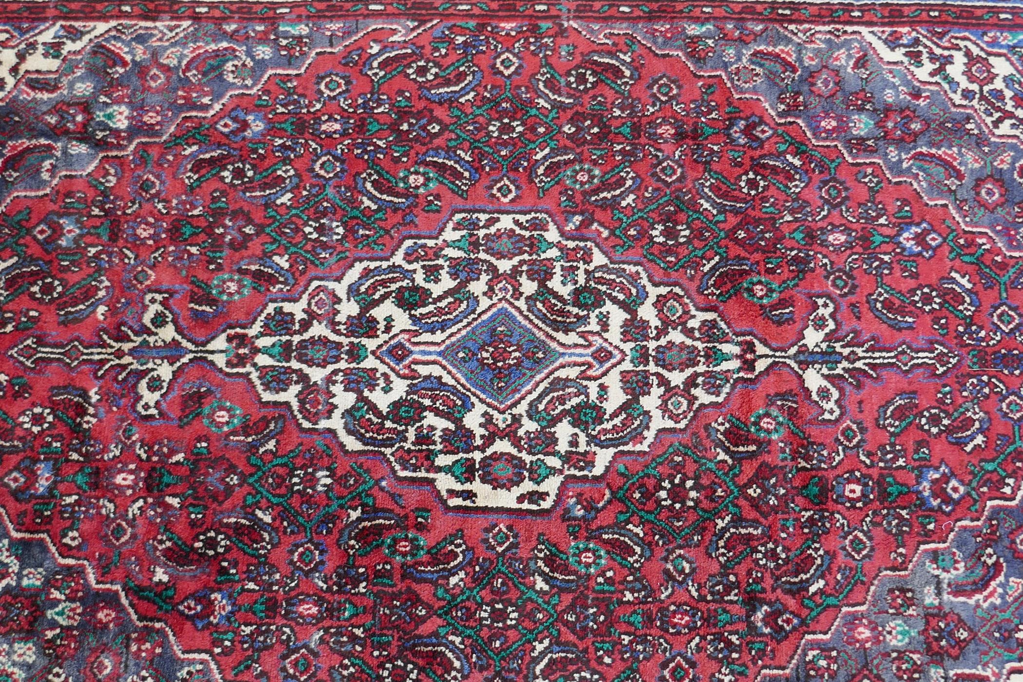 A red ground full pile Persian Sarouk carpet with traditional floral design, 83" x 122" - Image 2 of 4