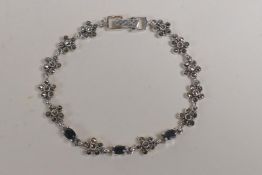 A silver and marcasite set bracelet with flower shape links, 6" long