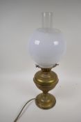 A brass oil table lamp converted to electricity with globe shade, 20" high